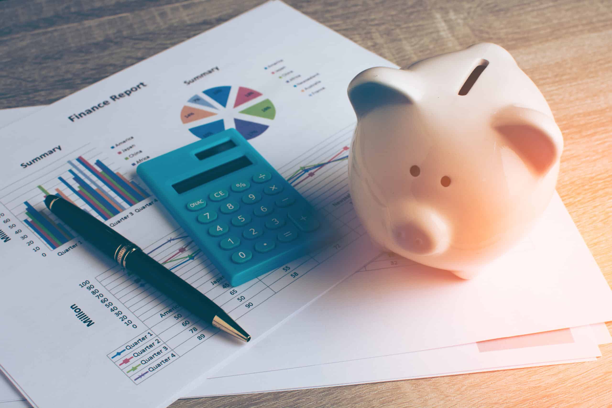 Piggy bank with calculator on wood table, business and finance c